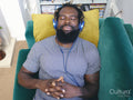 Man lying on sofa,listening to music on headphones