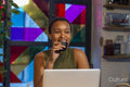 Smiling woman drinking tea and using laptop