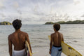 Indonesia, Lombok, Rear view of surfers looking at sea from beach