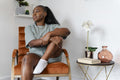 Portrait of young woman sitting in armchair at home