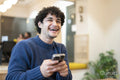 Smiling businessman using smart phone in office