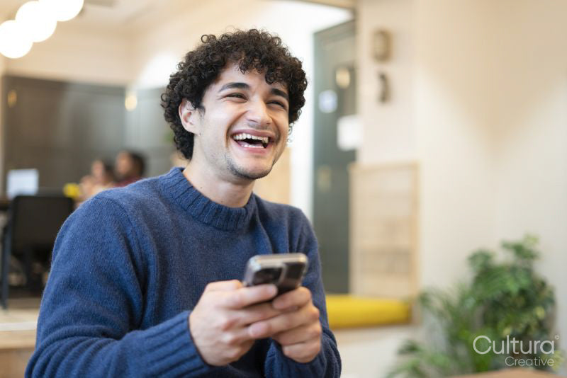 Smiling businessman using smart phone in office