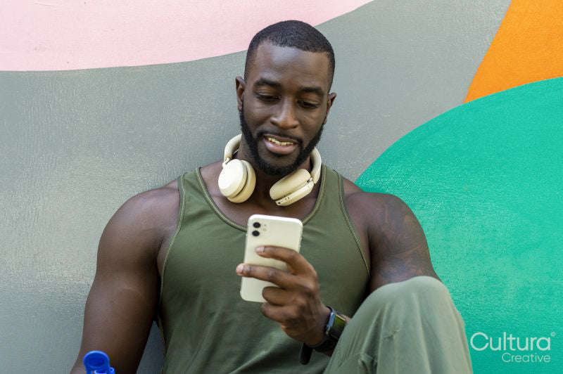 Mid adult man with headphones using phone