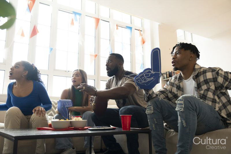 Friends watching sport game on TV at home