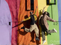 Two young women jumping in front of colorful graffiti wall
