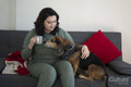 Woman and dog relaxing on sofa at home