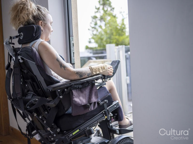 Woman in electric wheelchair going through front door
