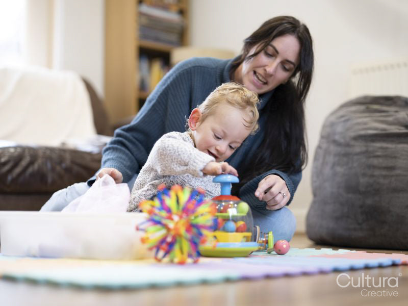 Mother looking at son playing with toys