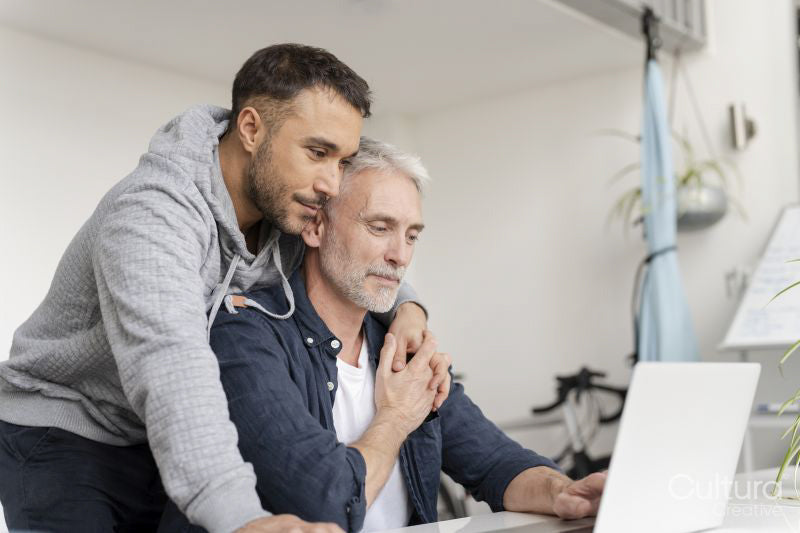 Male couple using laptop at home