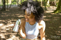 Young woman drinking water in forest