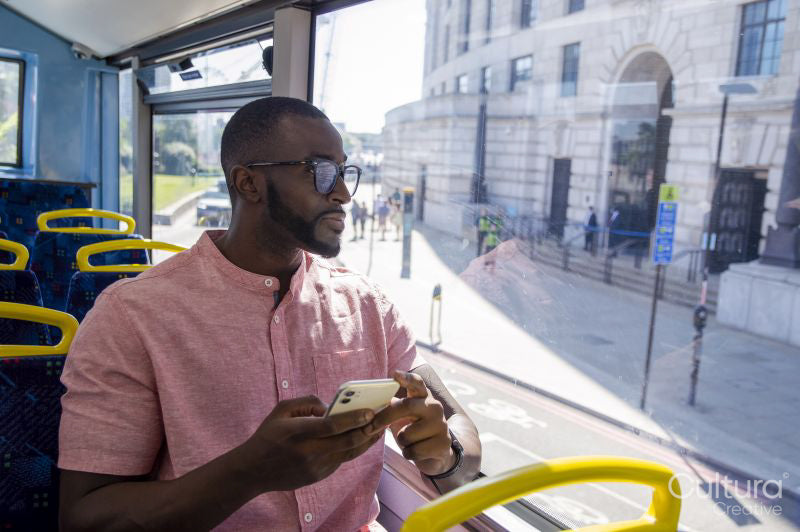 Man with smart phone sitting in bus