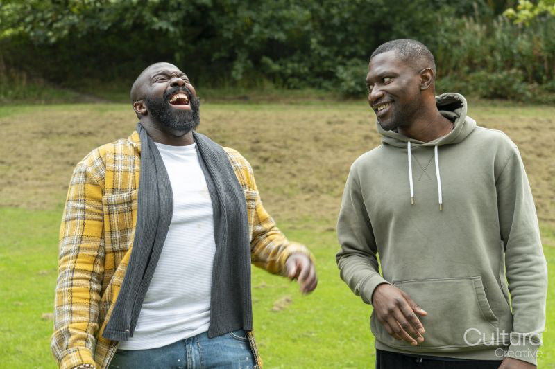 Two men laughing in park in autumn
