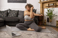 Woman exercising in living room in front of laptop