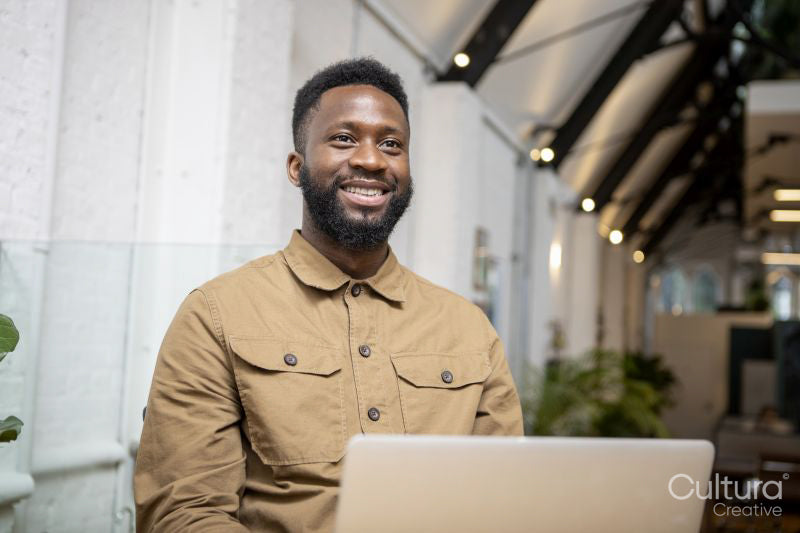 Smiling man using laptop at home