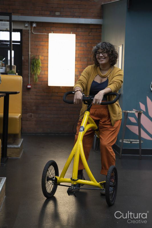 Portrait of mature woman with three-wheel walker in office