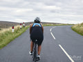 Rear view of female cyclist on country road
