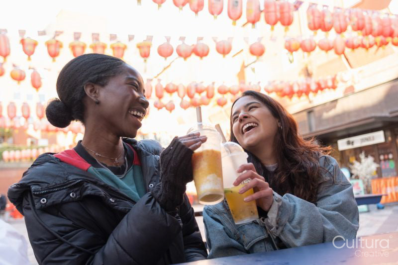 Portrait of two cheerful women drinking bubble tea in Chinatown