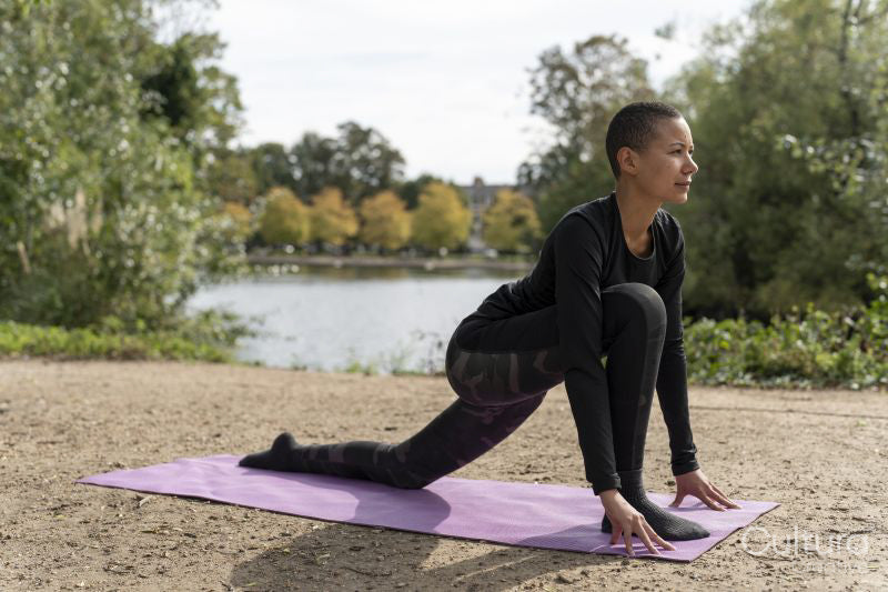 Woman in low lunge pose in park