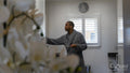 Man wearing bathrobe standing in kitchen