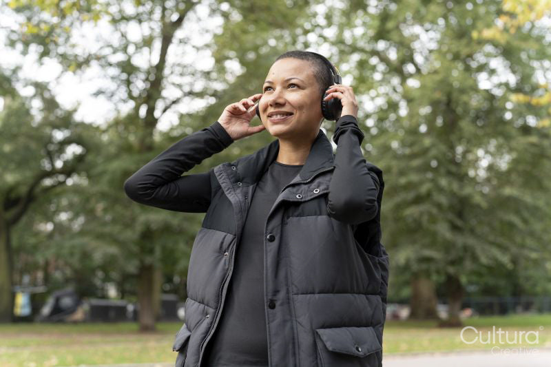 Portrait of smiling woman in sports clothing and headphones in park