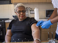Nurse visiting mature woman at her house, preparing injection