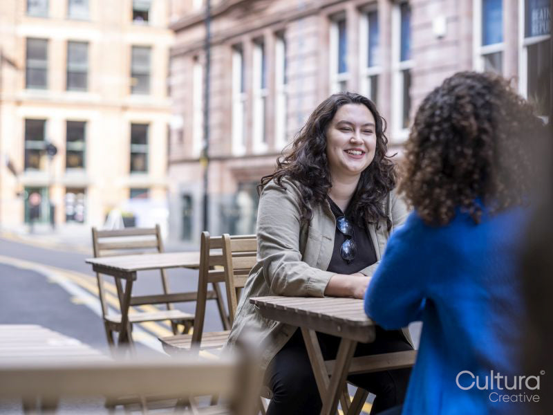 Smiling couple sitting at sidewalk cafe table