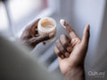 Close-up of person holding jar of moisturizer