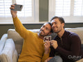 Pride couple taking selfie with ultrasound scan at home
