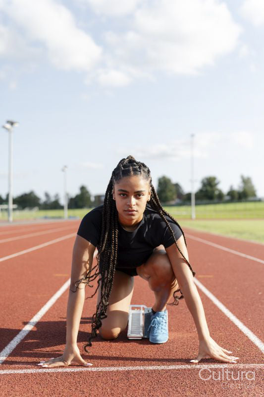 Female athlete preparing to run at stadium