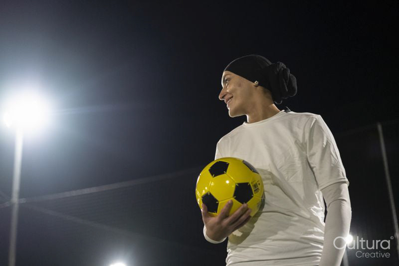 Female soccer player holding ball