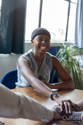 Woman in woolen cap smiling while holding hands with friends