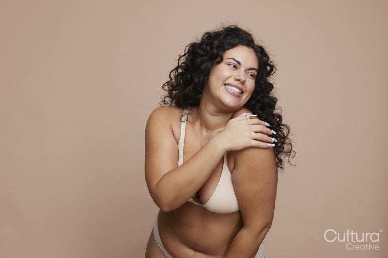 Studio shot of smiling young woman wearing lingerie