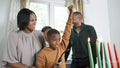Family with children lighting kinara candles