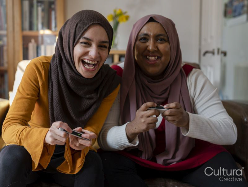 Smiling women playing video game at home