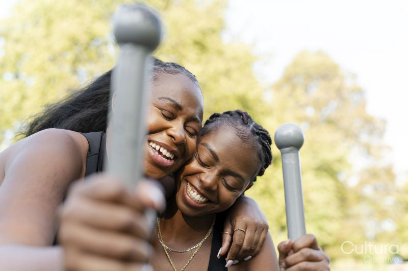 Smiling female friends hugging while exercising