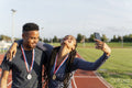 Portrait of male and female athlete celebrating with medals