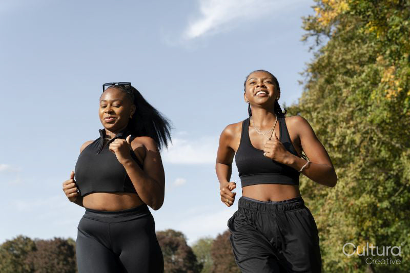 Young female friends jogging in park