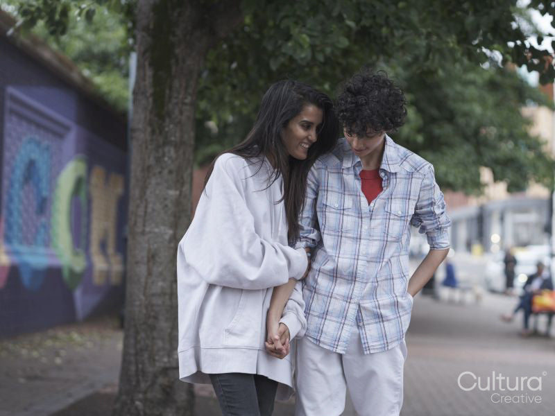 Female couple holding hands in street