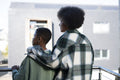 Mother and son standing on balcony