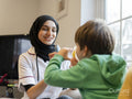 Nurse assisting boy using inhaler