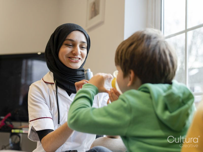 Nurse assisting boy using inhaler