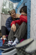 Mother and son camping in forest