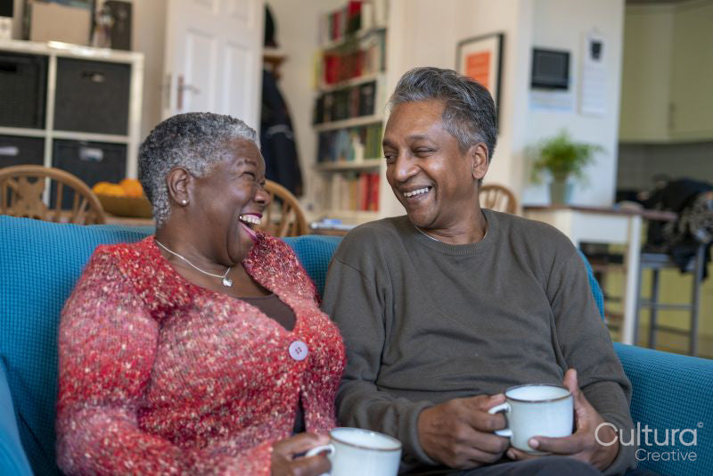 Senior couple sitting on sofa and drinking coffee
