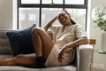 Portrait of smiling woman resting on sofa at home
