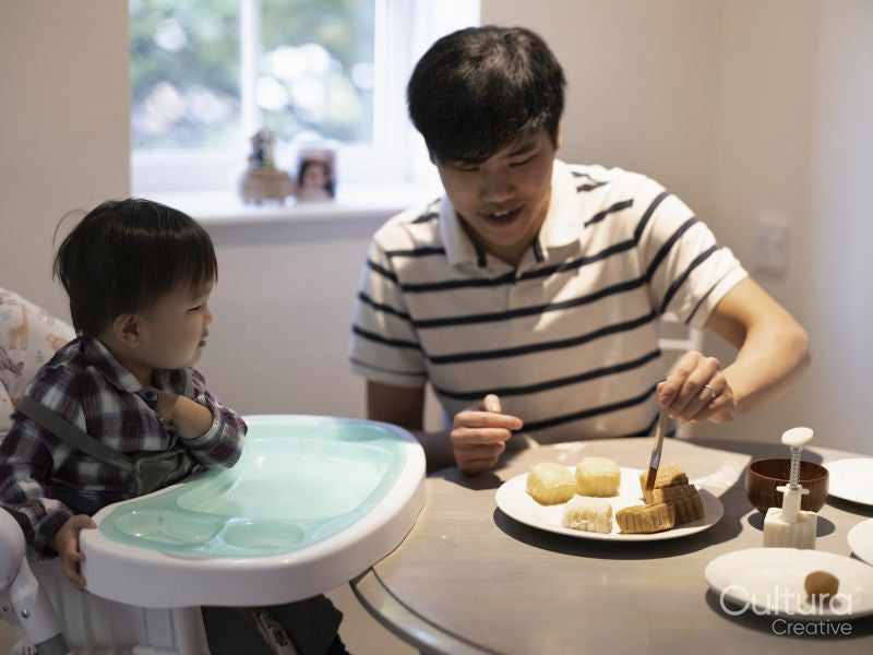 Father with baby son making moon cakes at home