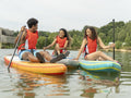 Friends having fun while paddleboarding on lake
