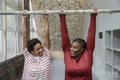 Mother and daughter doing chin-up exercise on bar