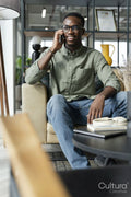 Young man with smartphone sitting in office lounge