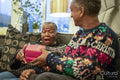 Senior couple sitting on sofa holding Christmas gifts