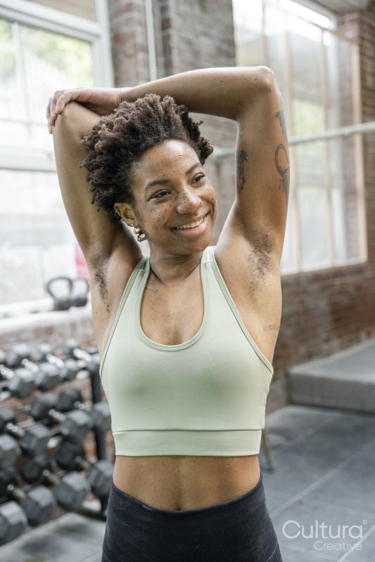 Woman stretching arms in gym before training
